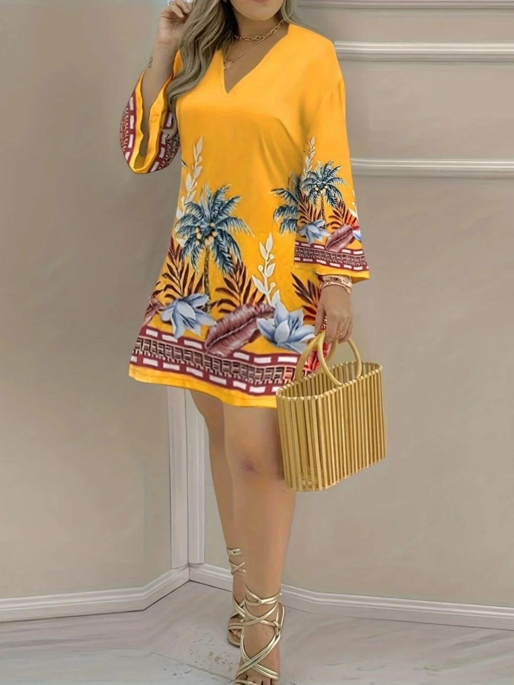 Femme portant une robe jaune évasée à motifs tropicaux, avec un sac en bambou